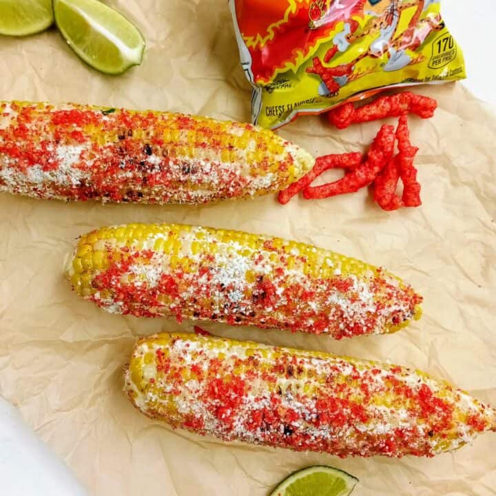 Elote with hot Cheetos topped with Cotija cheese and chili lime salt