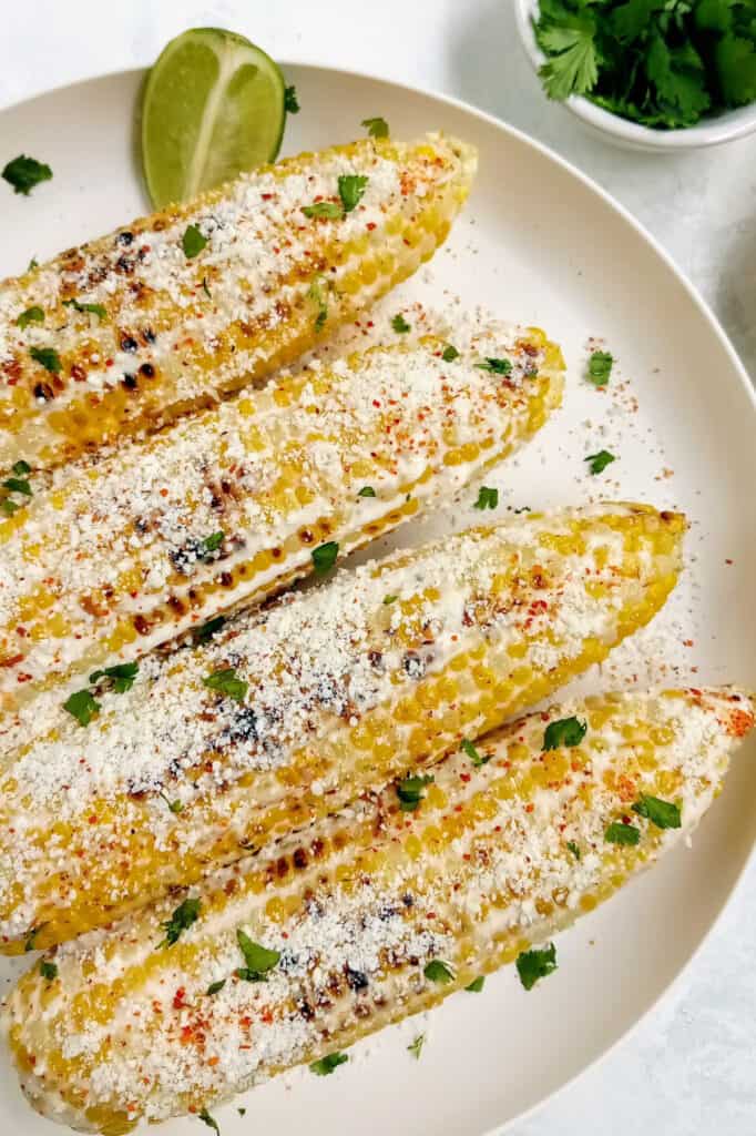 Mexican style corn on the cob coated in mayo and sour cream and topped with cilantro, chili lime salt and Cotija cheese.