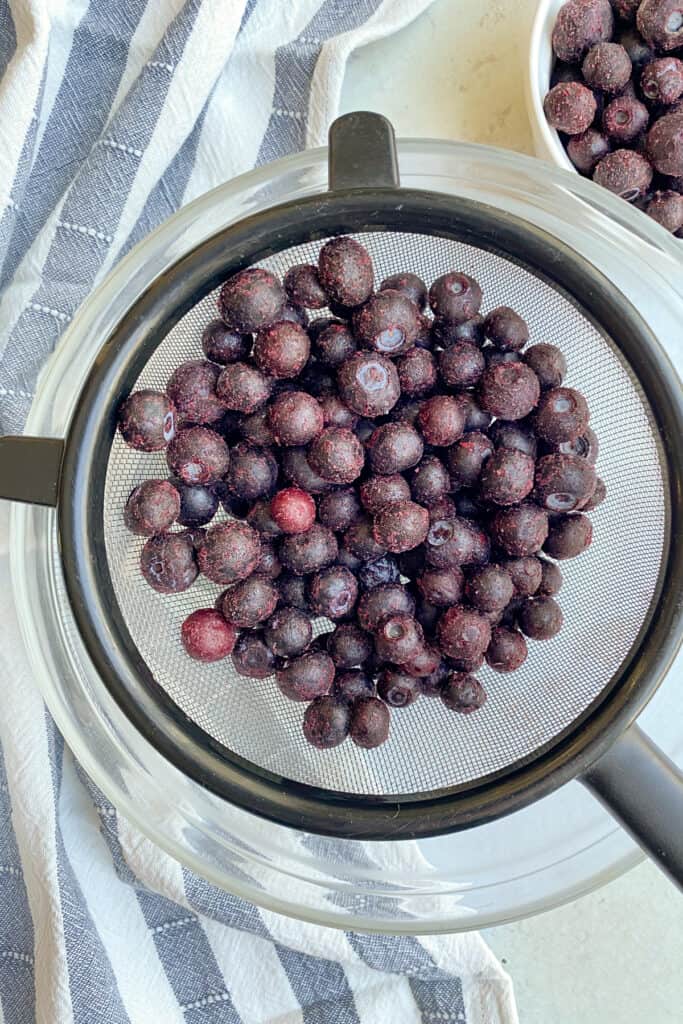 Frozen blueberries in a colander.