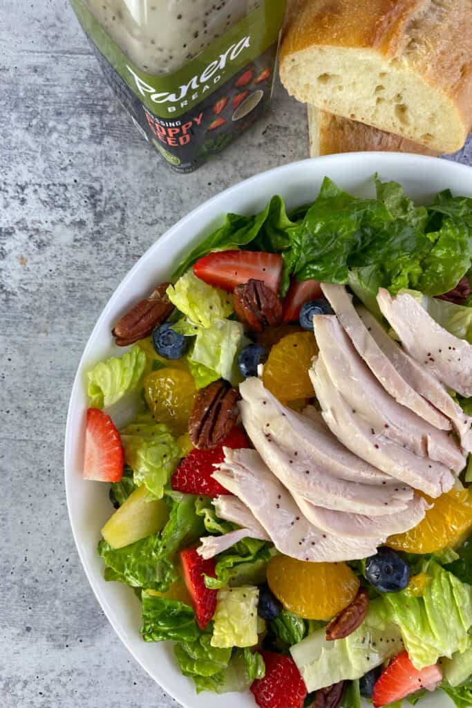 A Strawberry Poppyseed Salad with chicken made at home with bottled Panera salad dressing on top.