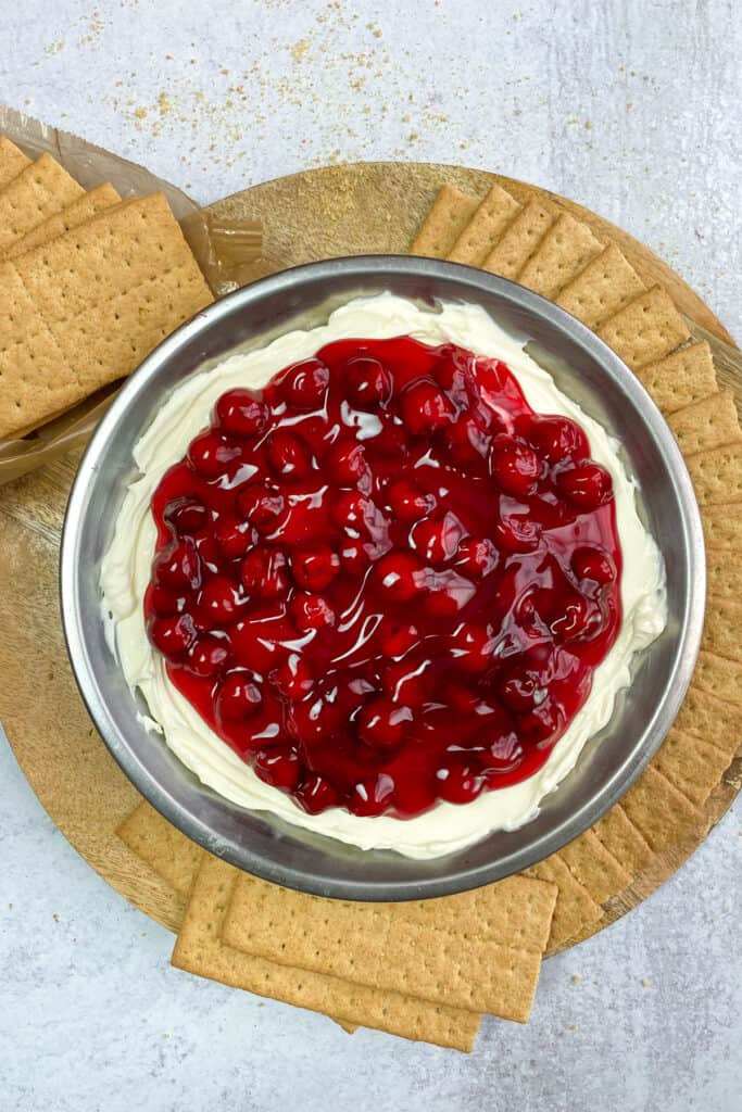Cheesecake dip topped with cherries with graham crackers for dipping.