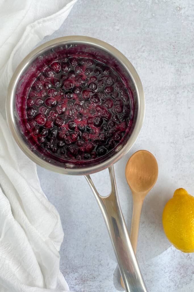 Simmering saucepan of blueberry compote.