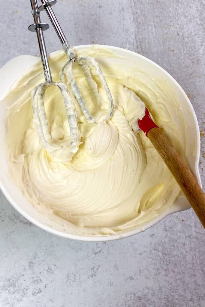 Bowl of whipped cheesecake dip with beaters covered with the dip.