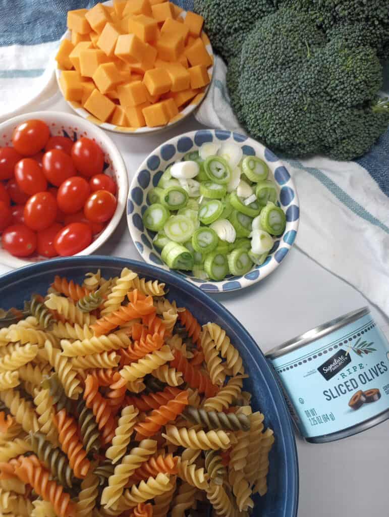 Grape tomatoes, green onions, tricolored pasta in individual bowls. ready to prepare. 