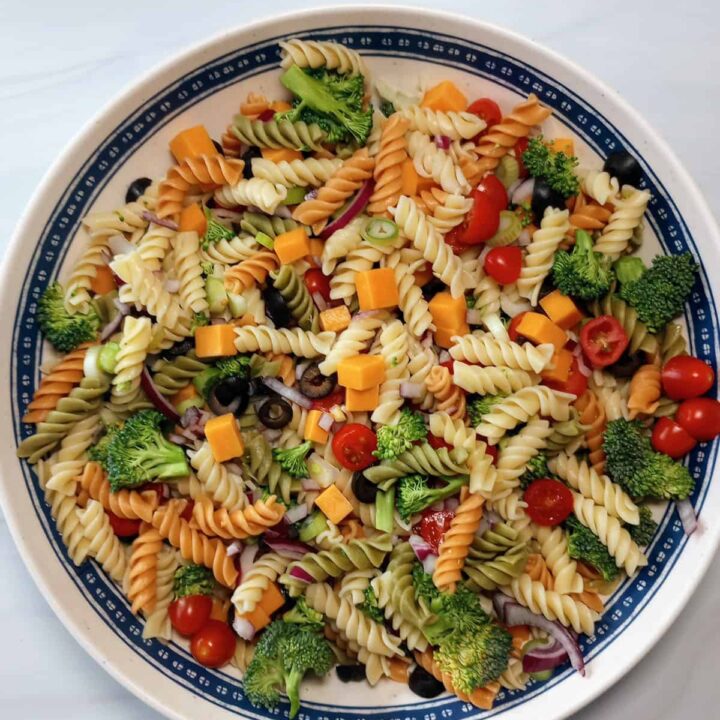 Cheddar broccoli pasta salad in a blue and white salad bowl.