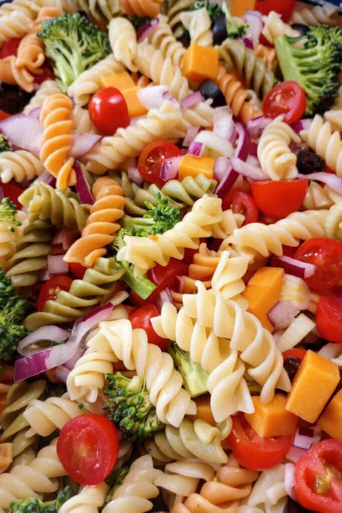Fresh vegetables and tricolored pasta in a salad bowl. 