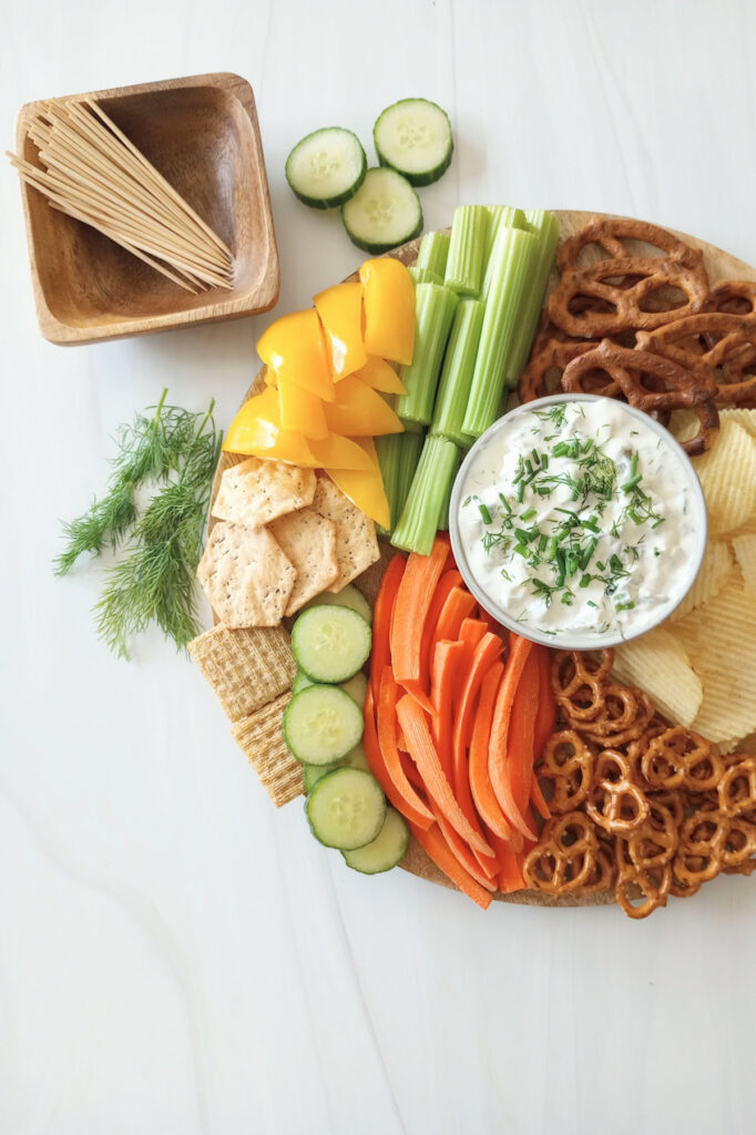 Dill Pickle dip with cream cheese. Served with fresh vegetables, bagel chips, triscuit crackers, and wedge potato chips.