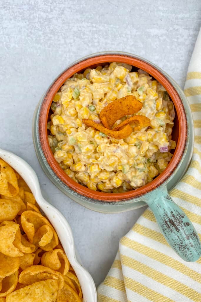 Bowl of Chili Cheese Frito Corn Dip with Chili Cheese Fritos garnished on top.