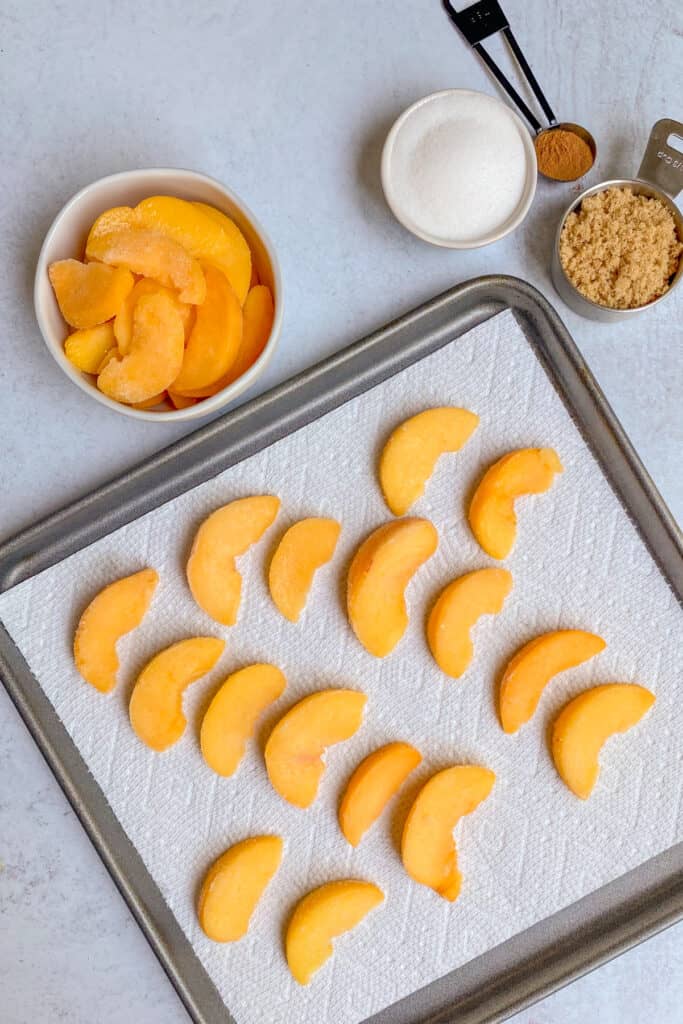 Thawing frozen peaches on a paper towel.