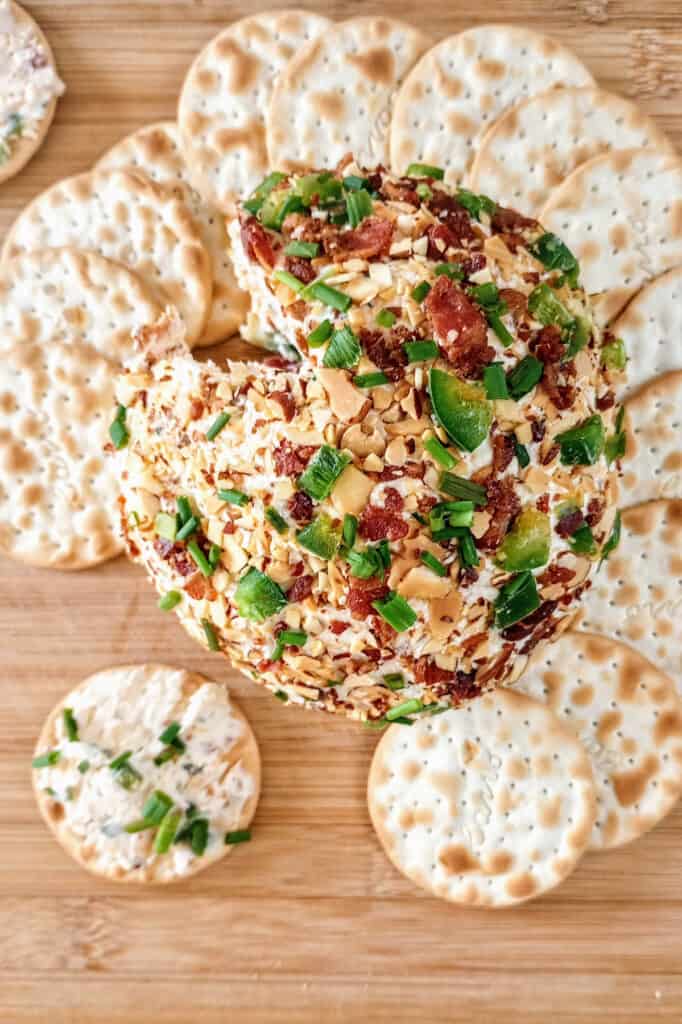 Cheese ball arranged around crackers ready to eat.