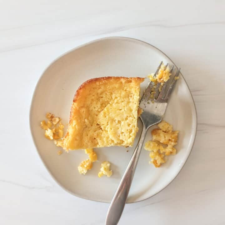 Jiffy corn casserole on a grey plate next to a fork.