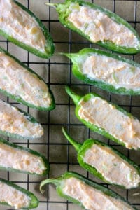 Cream cheese stuffed jalapenos ready to be wrapped in bacon.