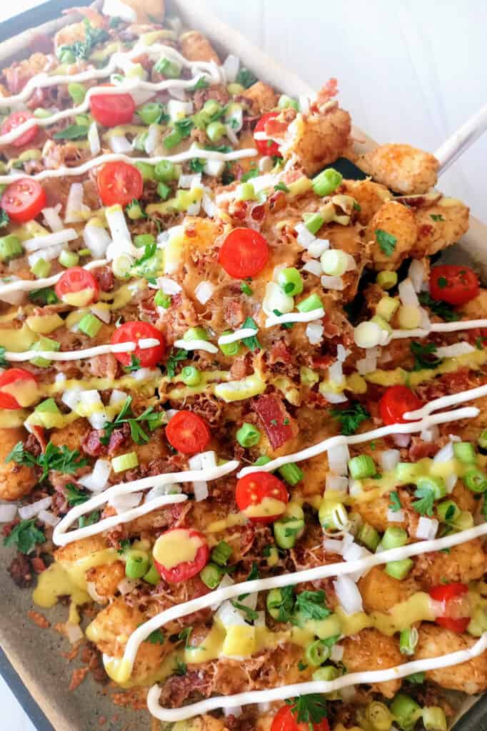 Tater tot nachos (loaded totchos) are crispy tater tots topped with melted cheese, and all your favorite nacho toppings. This appetizer takes just minutes to make!