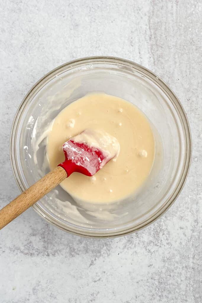 Vanilla glaze being stirred together in bowl.