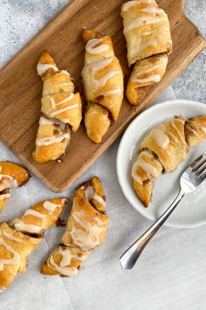 Dessert crescent rolls ready to serve with one on a small dessert plate with fork.