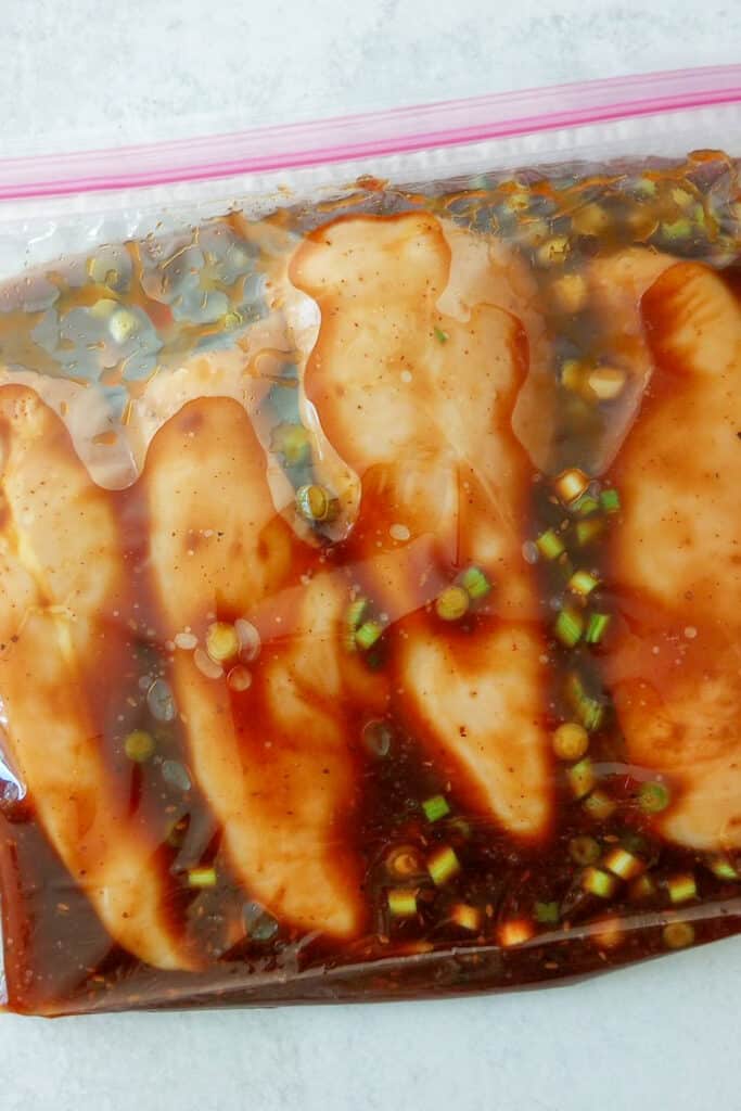 Marinated chicken breasts in a gallon-sized zip lock bag.  