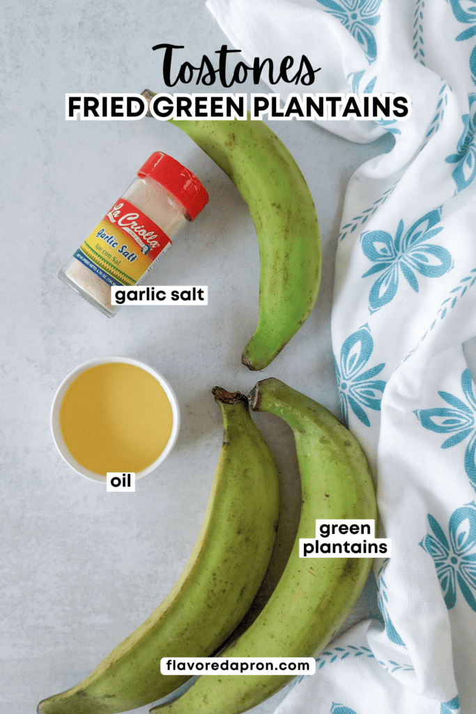 Ingredients needed to make tostones recipe, including green plantains, oil for frying and garlic salt.