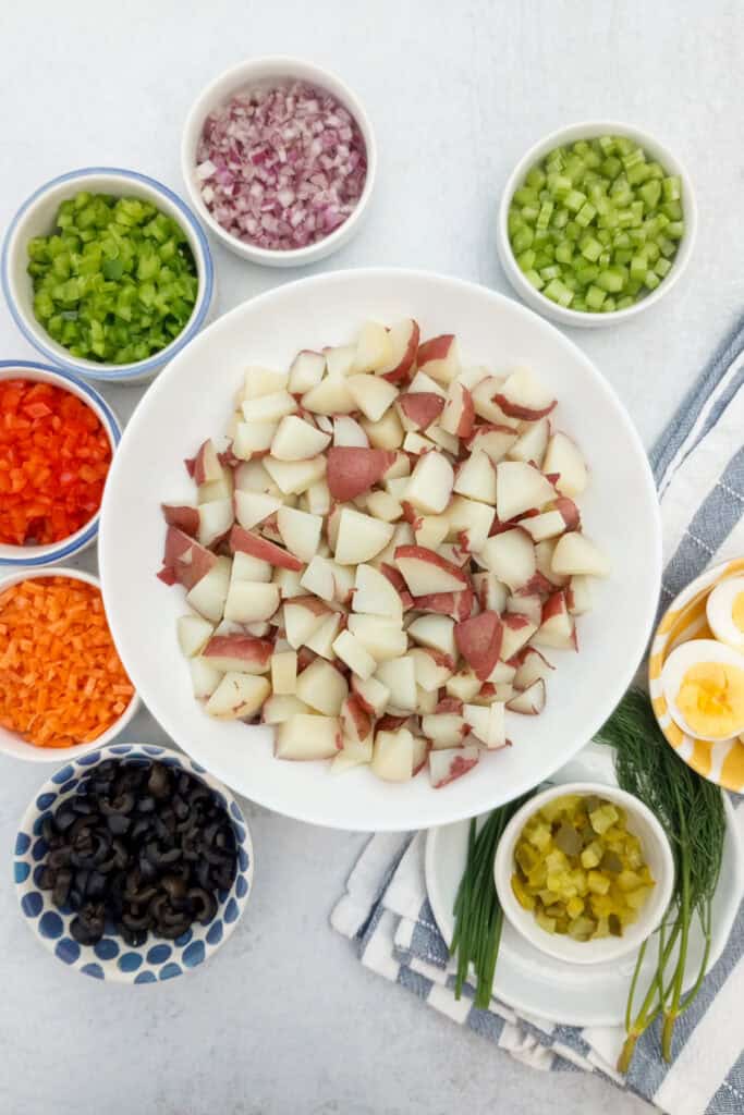 Chopped red potatoes and lots of diced fresh veggies for making potato salad.