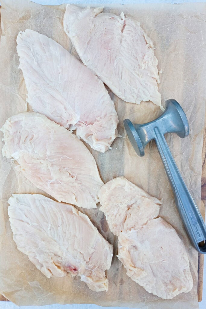 Chicken breasts are ready to be flattened out with a meat tenderizer. 