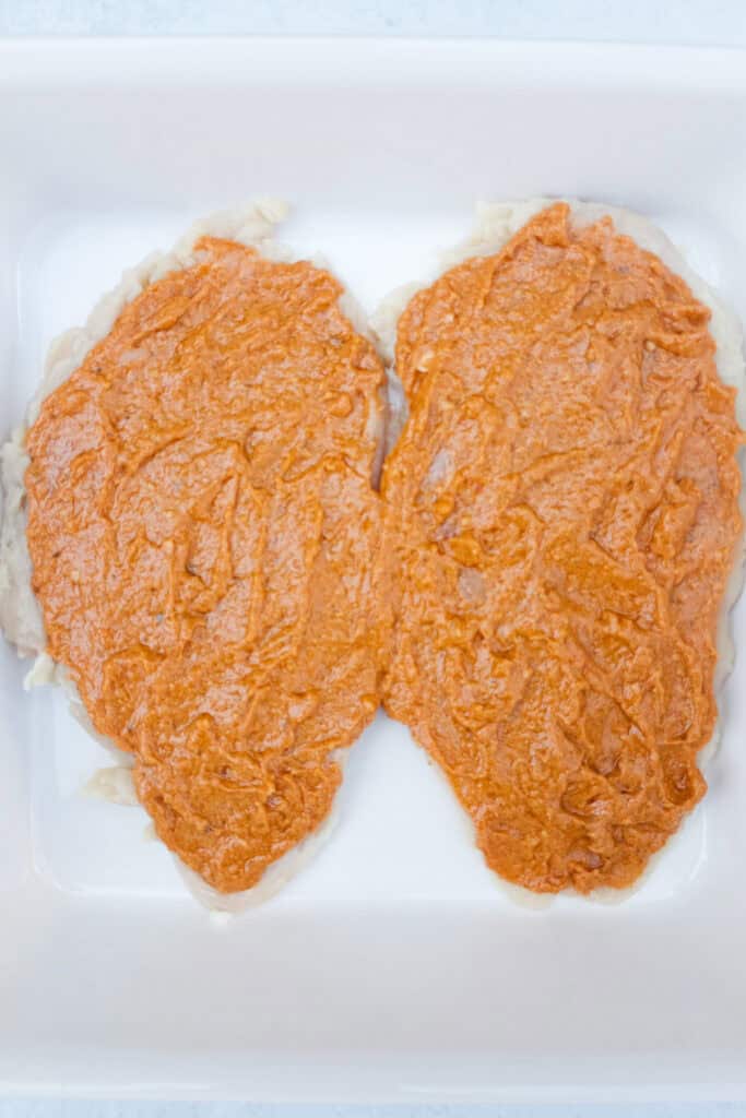 Step one coat the inside of chicken breasts with red pesto sauce.