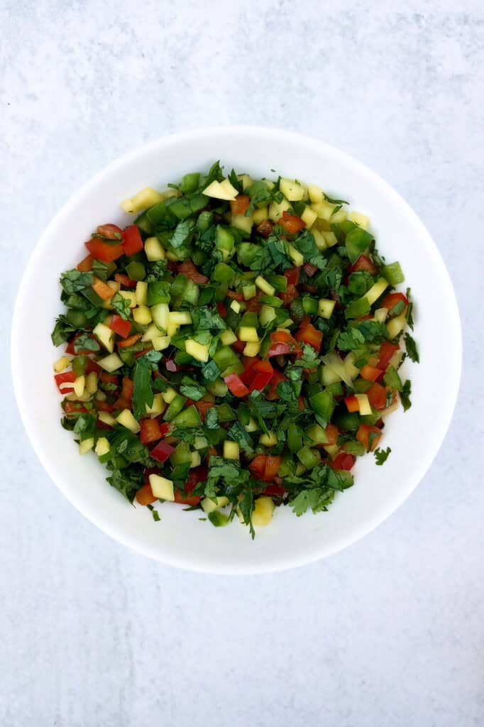 Mango salsa in a white bowl. 