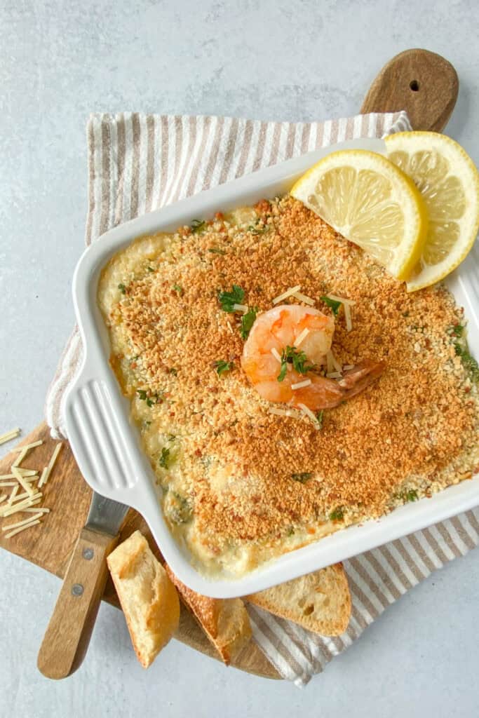 Seafood dip fresh out of the oven served with warm baguette bread. 