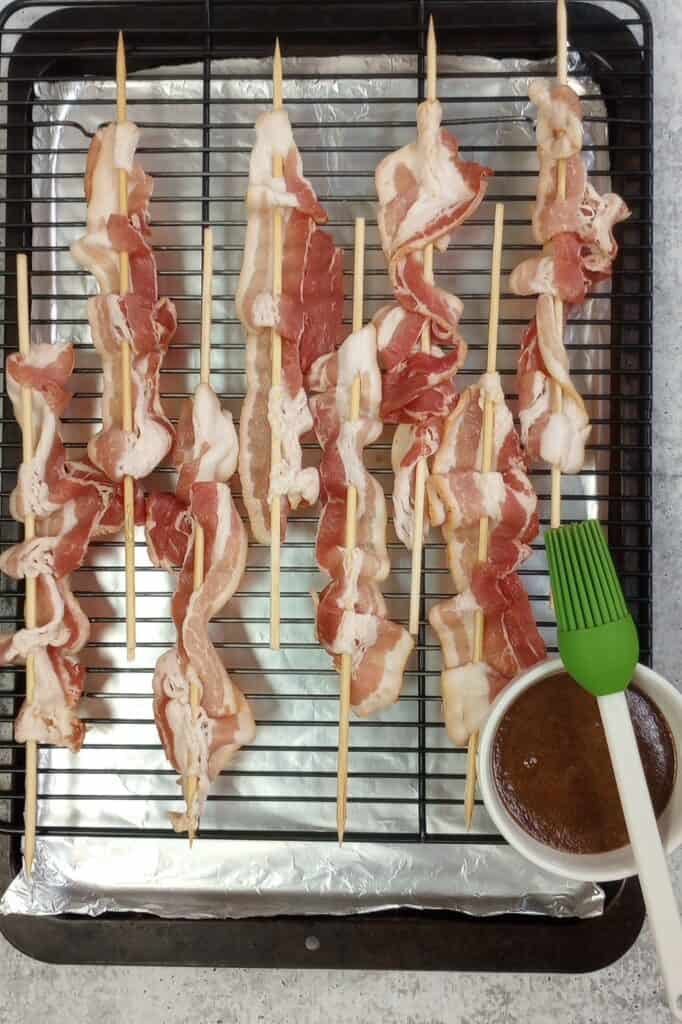 Twisted bacon on a skewer ready to be brushed with brown sugar glaze.