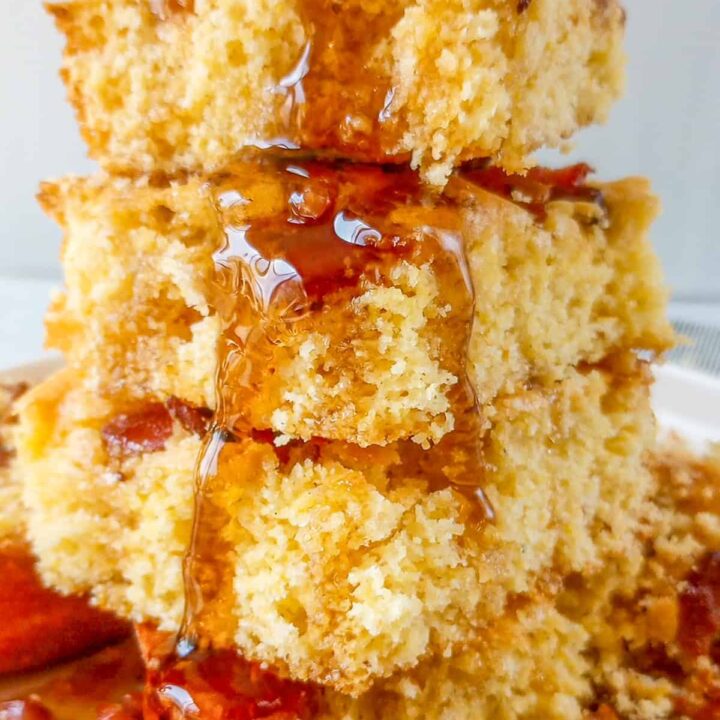 Maple bacon cornbread cut into squares and stacked on top of each other.