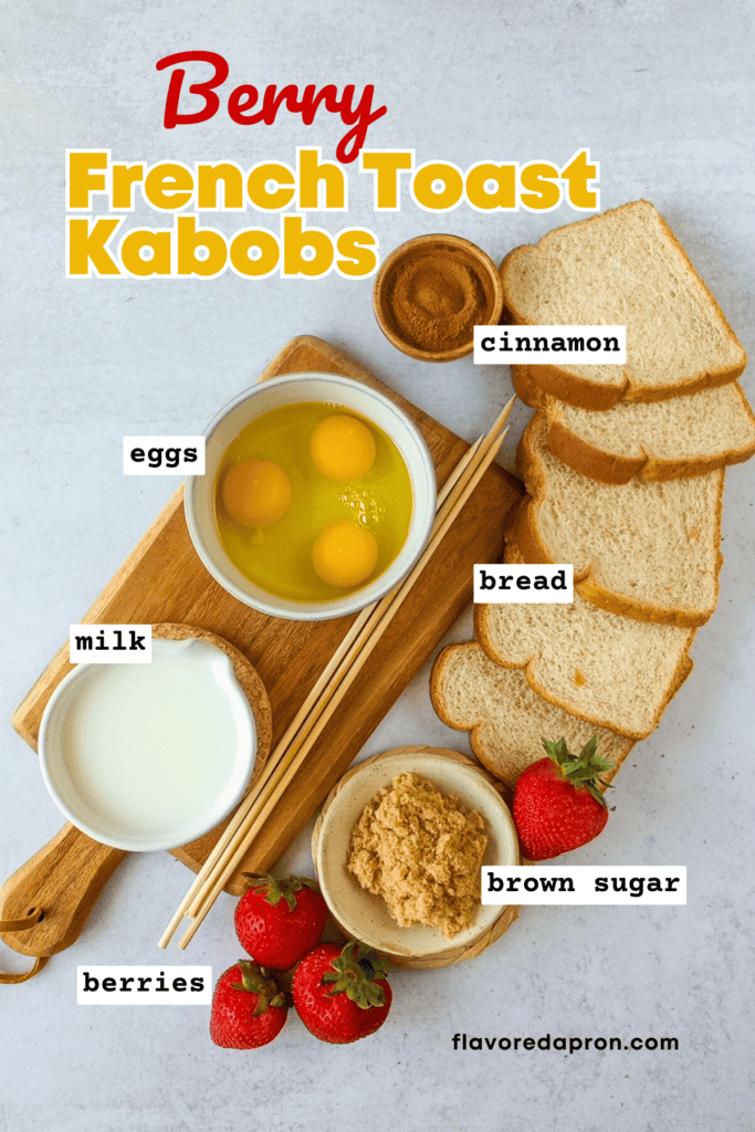 Overhead picture showing ingredients to make french toast kabobs, including bowl with eggs, small bowl of cinnamon, milk, slices of bread, bowl of brown sugar, some strawberries and wooden skewers.