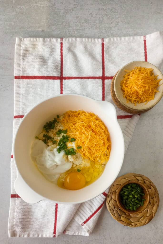 All ingredients in a white bowl are ready to be blended together. 