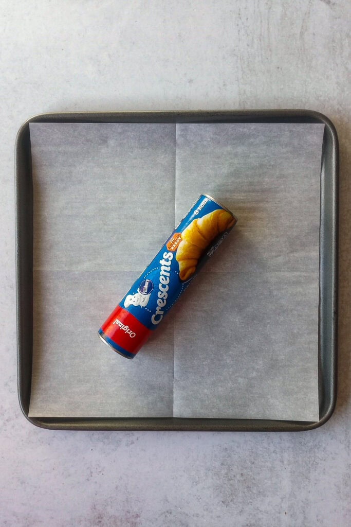 Pillsbury Crescent rolls on a baking sheet lined with parchment paper. 