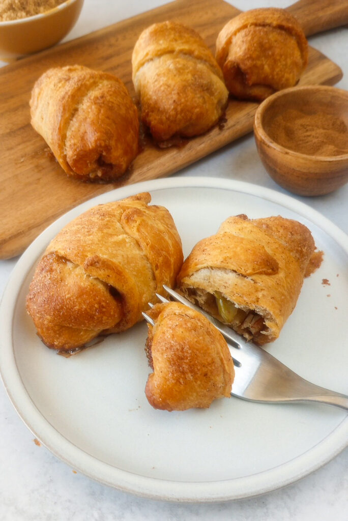 Up close picture of apple pie bites on a dessert plate with a dessert fork.