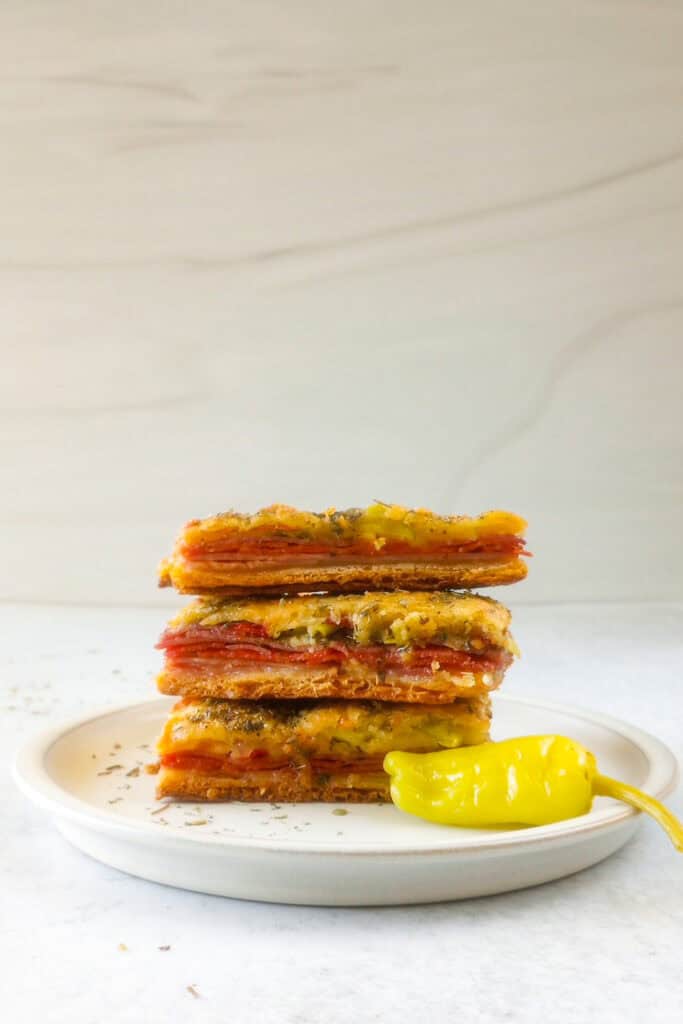 Picture of antipasto squares on a white plate. 