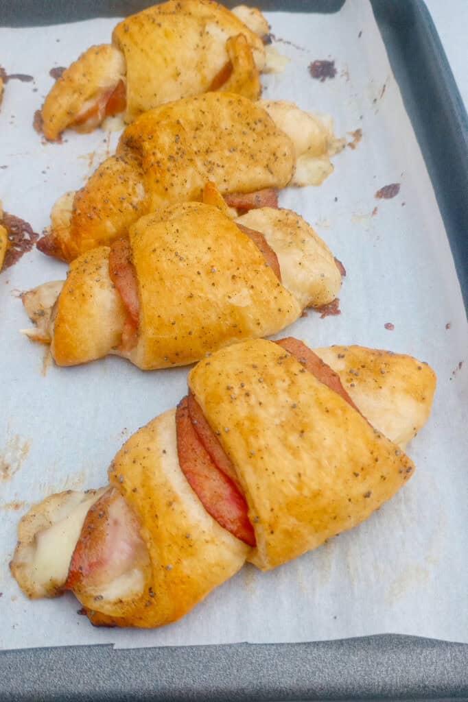 Picture of ham and cheese sticks on a baking sheet. 