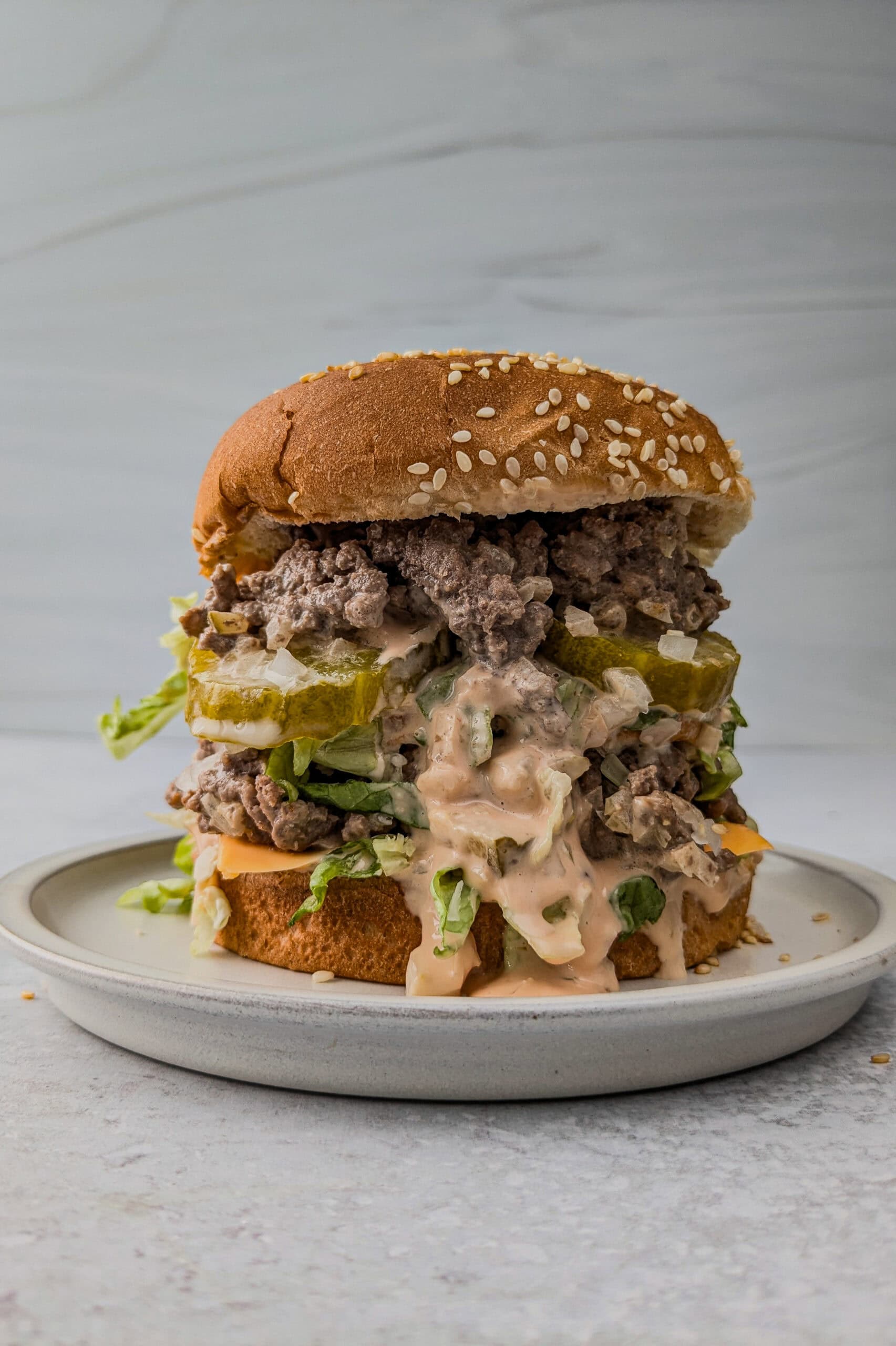 Picture of big Mac sloppy Joe on a plate with big Mac sauce oozing out of the front of the sandwich.