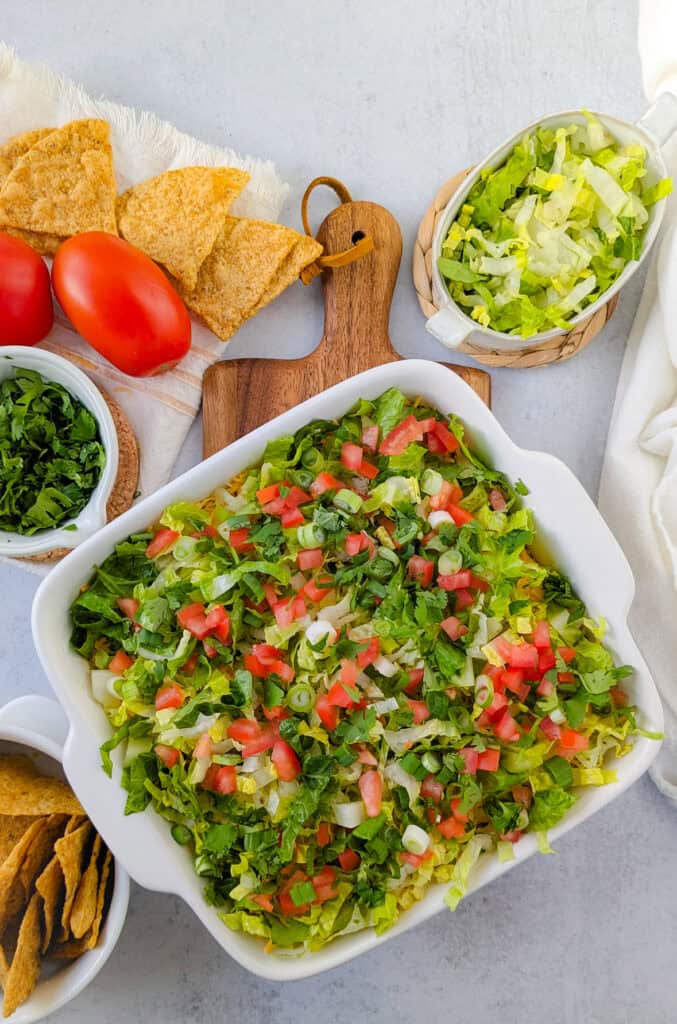 Overhead picture of layered Mexican dip with refried beans and cream cheese. 