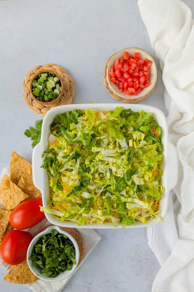 Overhead picture of 4 layer taco dip topped with shredded lettuce. 