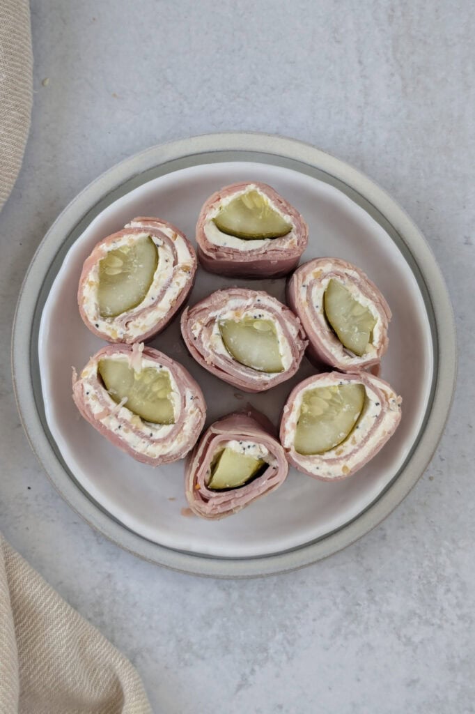 Overhead picture of sliced pickle wraps on a plate. 