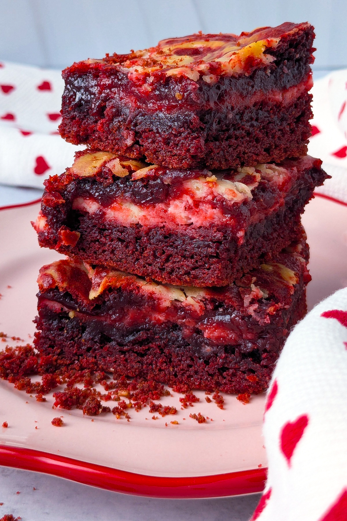 Up close picture of brownies on a pink and red plate.