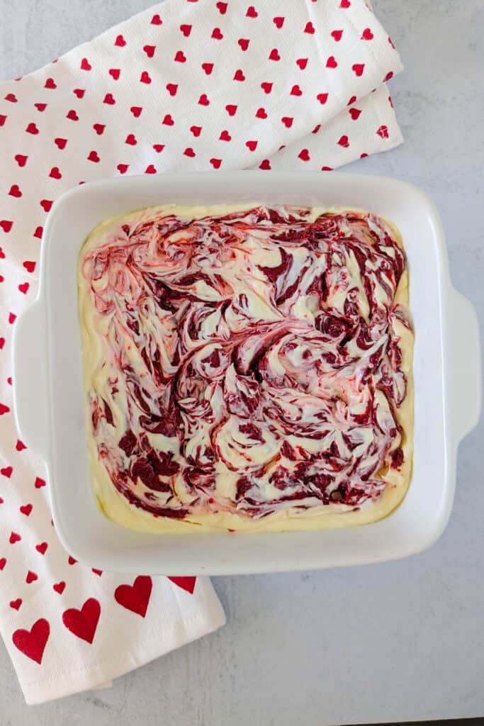 Overhead picture of brownie and cheesecake batter swirled. 