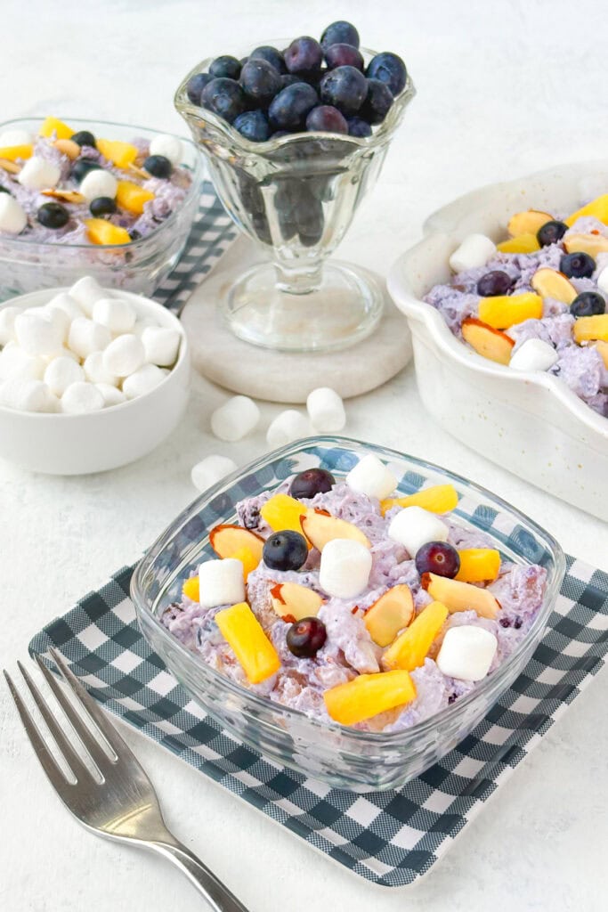 Picture of blue berry fluff in glass jars on checkered plates.
